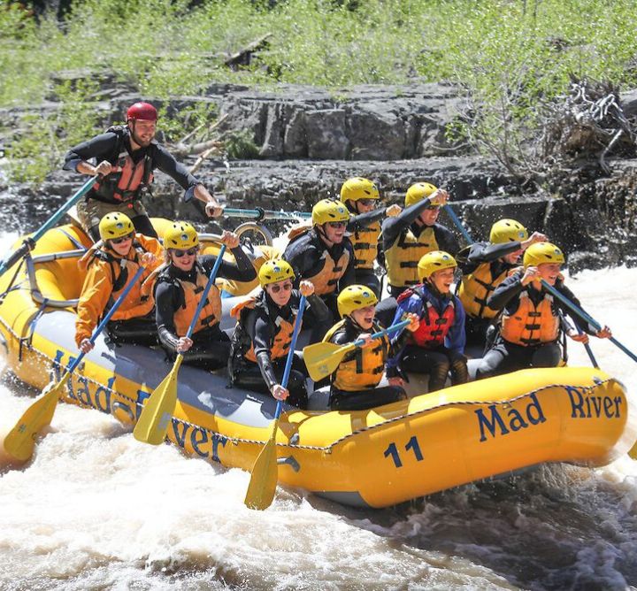 People whitewater rafting down a river.